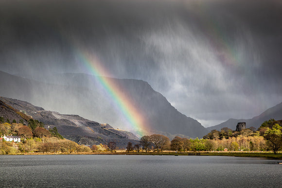 Four Seasons in One Day - Llanberis, Snowdonia - two rainbows can be seen through the storm clouds and rain above the lake of Llyn Padarn in North Wales